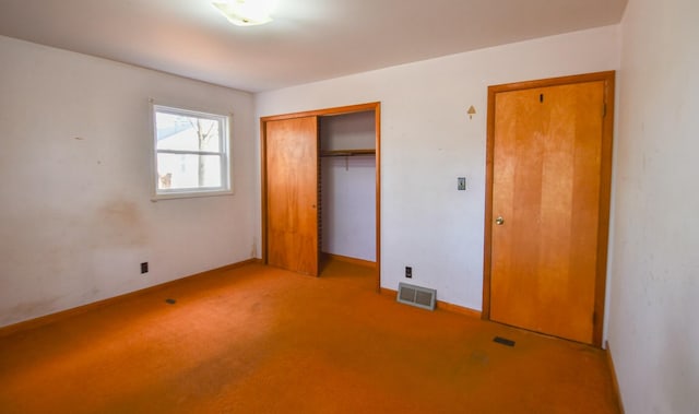 unfurnished bedroom with light colored carpet and a closet