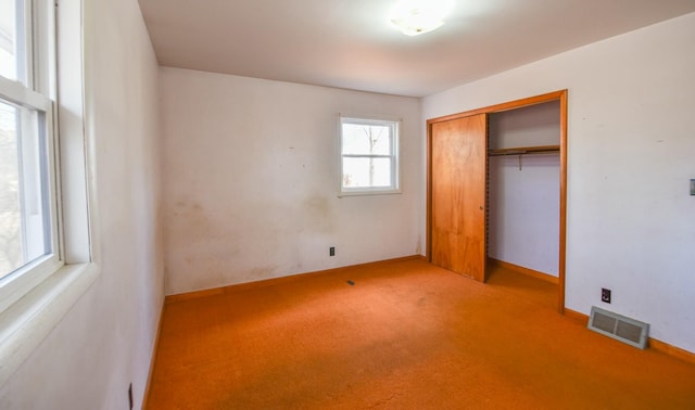 unfurnished bedroom with light carpet and a closet