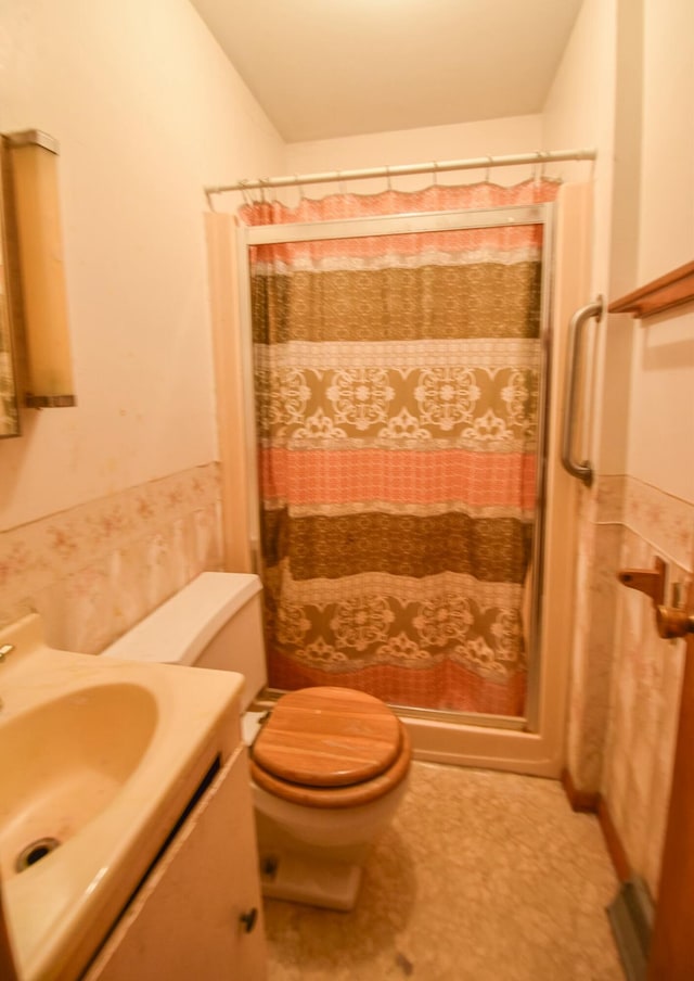 bathroom featuring a shower with curtain, toilet, and vanity