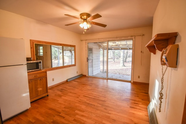 interior space with light hardwood / wood-style floors, a wealth of natural light, and ceiling fan