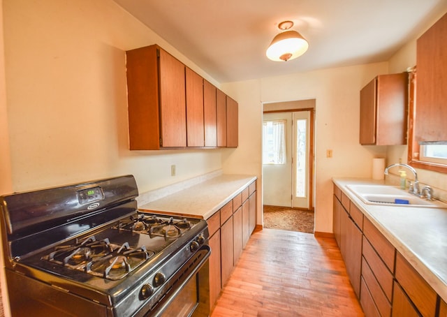 kitchen with sink, light wood-type flooring, and black range with gas cooktop