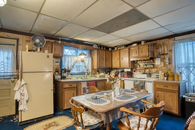 kitchen with a paneled ceiling, sink, white fridge, and decorative light fixtures