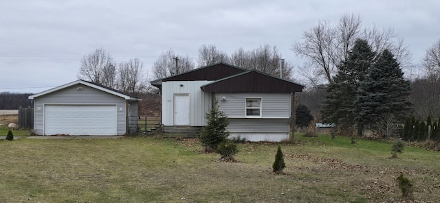 view of front facade featuring an outbuilding, a garage, and a front yard