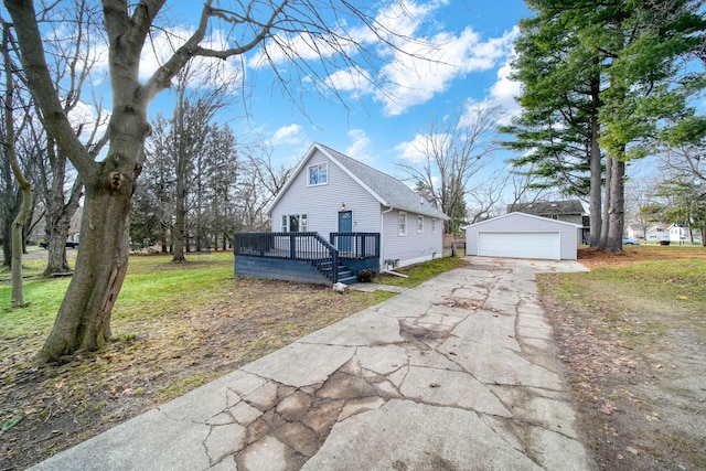 view of front of property with a garage, a deck, an outbuilding, and a front yard