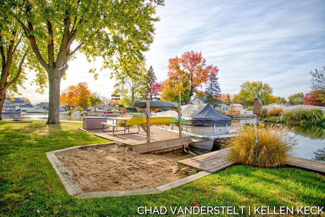 dock area with a lawn and a water view