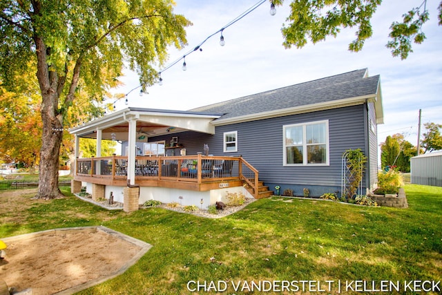 rear view of property featuring a deck and a yard