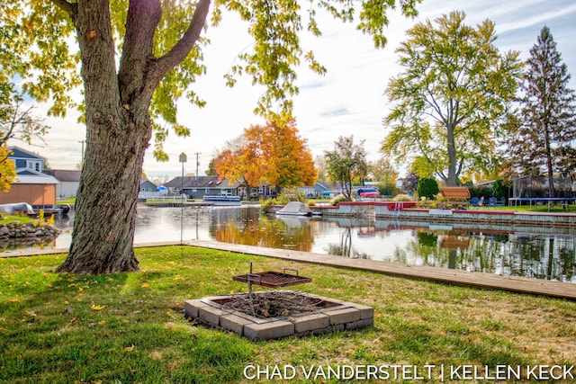 view of yard with a water view and an outdoor fire pit