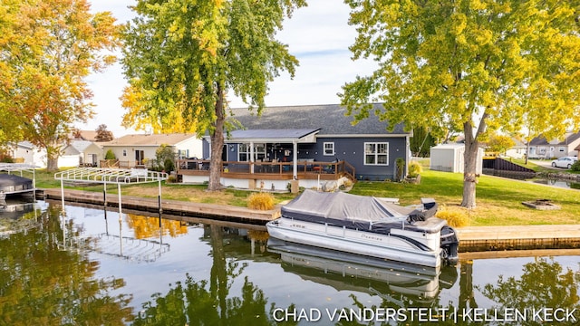 view of dock with a deck with water view and a yard