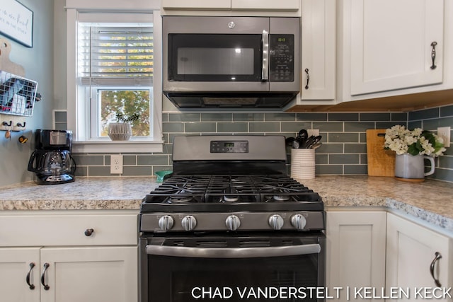 kitchen with stainless steel appliances, white cabinetry, and tasteful backsplash