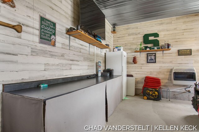 interior space featuring heating unit and wooden walls