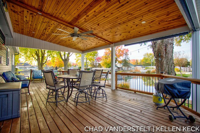 deck featuring ceiling fan, a water view, and grilling area