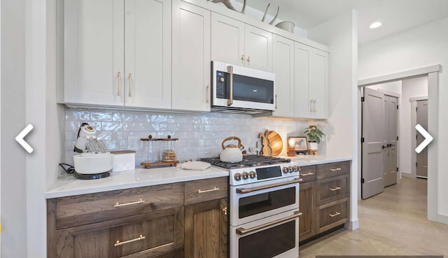 kitchen featuring decorative backsplash, dark brown cabinetry, white cabinetry, and stainless steel appliances