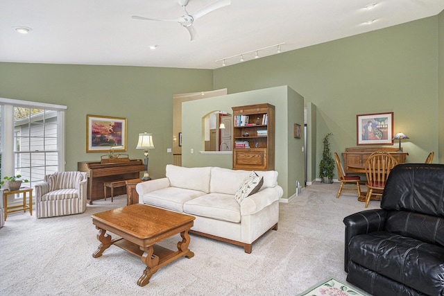 carpeted living room featuring track lighting, vaulted ceiling, and ceiling fan