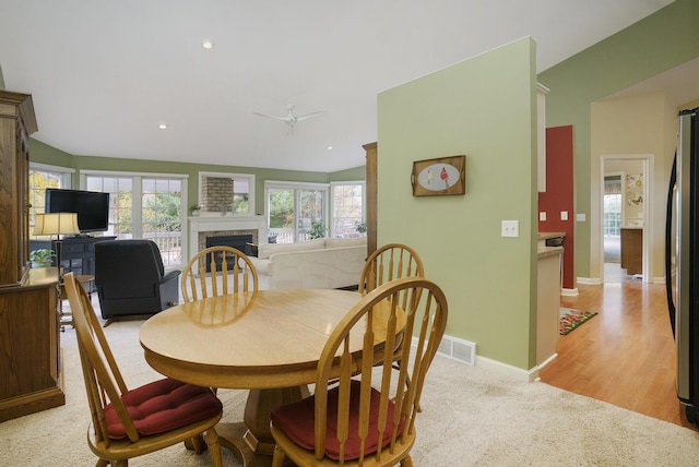 dining area with light hardwood / wood-style flooring, ceiling fan, and lofted ceiling