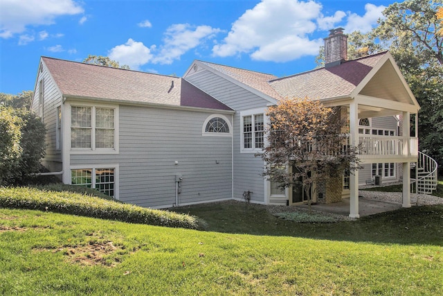 rear view of house featuring a yard and a patio