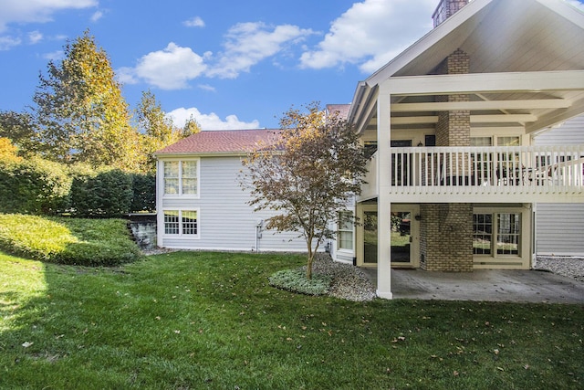 view of property exterior with a yard and a patio