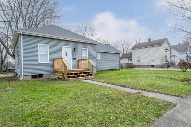 rear view of house featuring a lawn and a deck