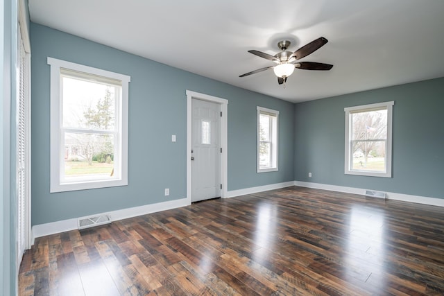 empty room with ceiling fan, dark hardwood / wood-style flooring, and a healthy amount of sunlight