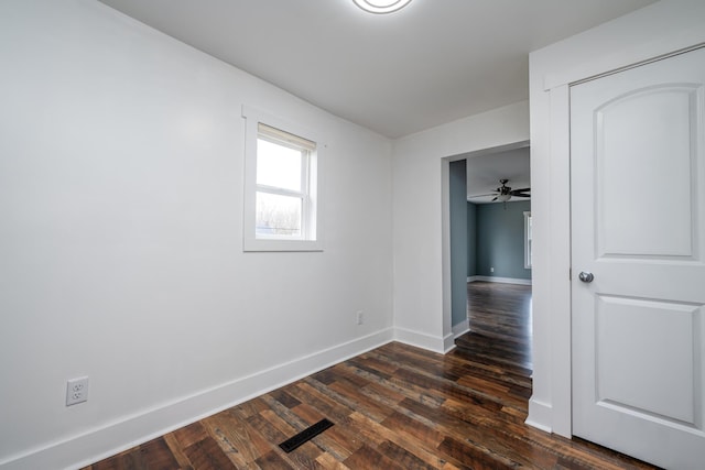 empty room featuring ceiling fan and dark wood-type flooring