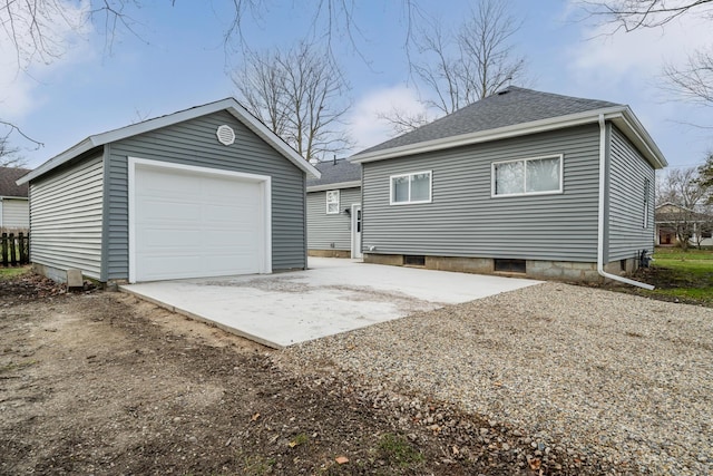 exterior space featuring a garage and an outbuilding