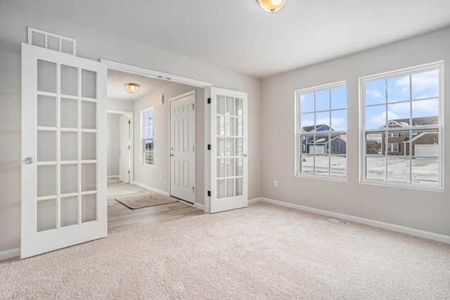 empty room featuring light carpet and french doors