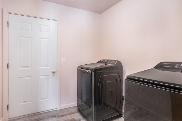 laundry area featuring washer and dryer and light hardwood / wood-style floors