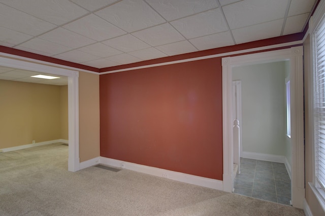 spare room featuring carpet floors, plenty of natural light, and a paneled ceiling