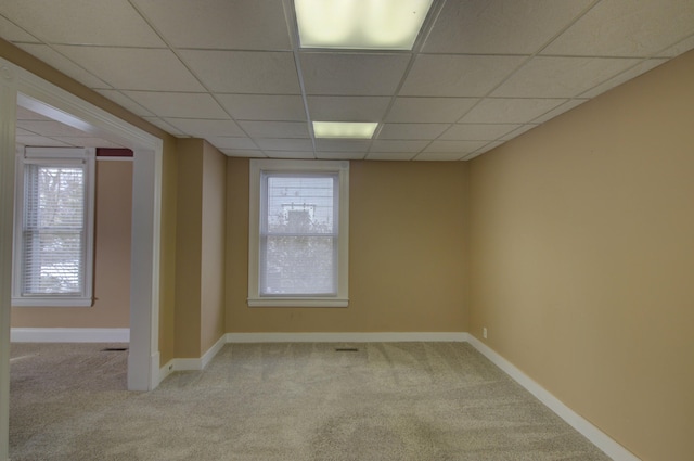 carpeted spare room featuring a paneled ceiling