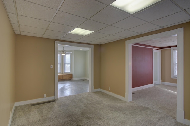 spare room featuring a paneled ceiling, light carpet, and ceiling fan