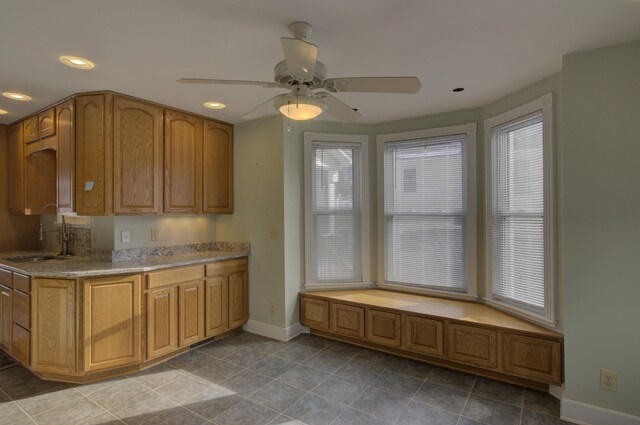 kitchen featuring tile patterned floors, ceiling fan, and sink