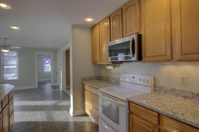 kitchen featuring white electric range oven, ceiling fan, light stone counters, and dark tile patterned floors