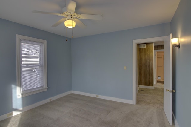 carpeted spare room with ceiling fan