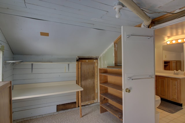 interior space featuring a barn door, sink, and lofted ceiling