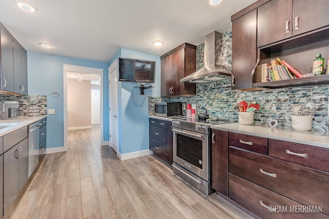 kitchen featuring backsplash, wall chimney exhaust hood, light hardwood / wood-style floors, dark brown cabinetry, and stainless steel appliances