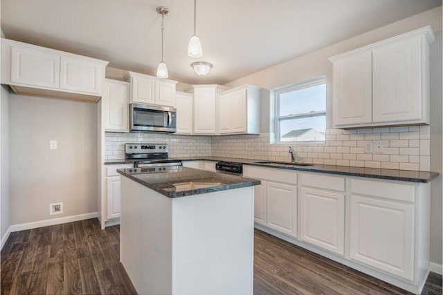 kitchen featuring dark wood-style floors, stainless steel appliances, a sink, and white cabinets