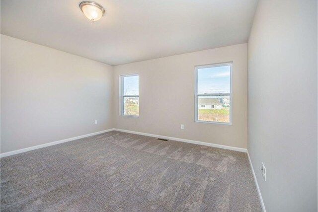 empty room with carpet floors and baseboards