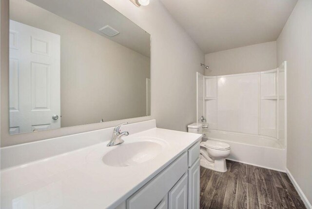 full bathroom with wood finished floors, bathtub / shower combination, vanity, and toilet