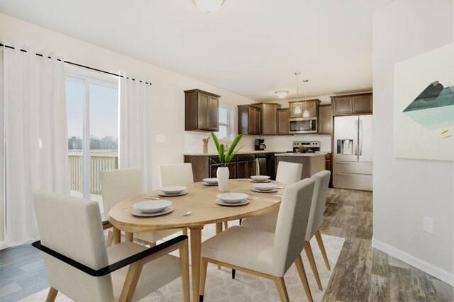 dining space with light wood finished floors, plenty of natural light, and baseboards