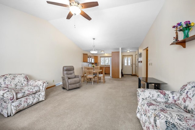 carpeted living room with ceiling fan and lofted ceiling