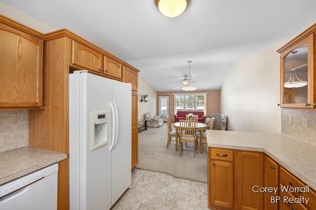 kitchen with lofted ceiling, white appliances, ceiling fan, tasteful backsplash, and light colored carpet