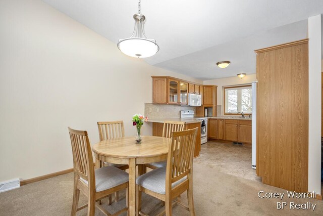 dining area with sink and light carpet