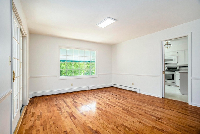 unfurnished room featuring a baseboard radiator and light hardwood / wood-style flooring