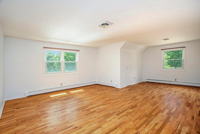 unfurnished room with a healthy amount of sunlight, light hardwood / wood-style floors, and baseboard heating