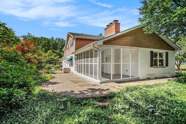 rear view of property featuring a patio area and a sunroom