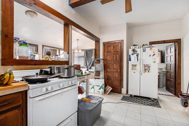 kitchen featuring ceiling fan with notable chandelier, white appliances, vaulted ceiling, and sink