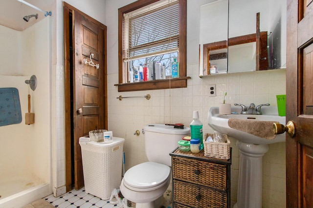 bathroom with tile patterned floors, a shower, tile walls, and toilet