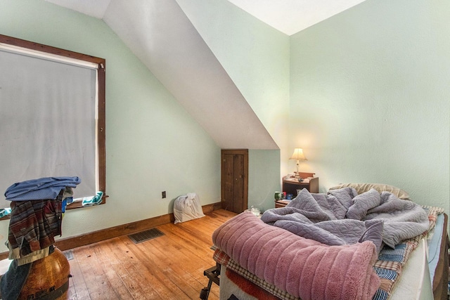 bedroom featuring light hardwood / wood-style floors and lofted ceiling