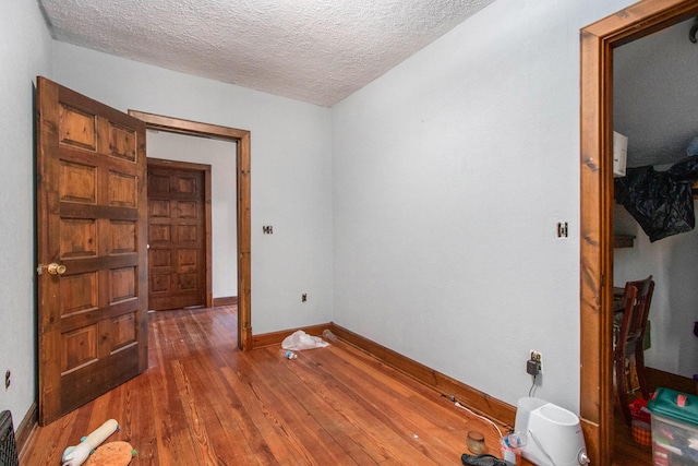 unfurnished room featuring a textured ceiling and dark hardwood / wood-style floors