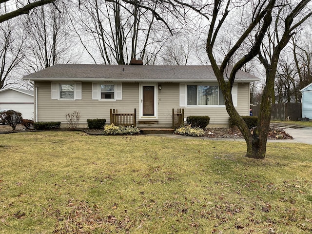 single story home with an outbuilding, a garage, and a front lawn