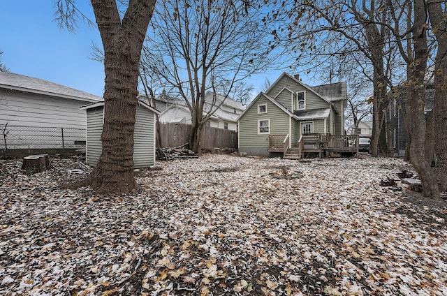 snow covered rear of property with a deck